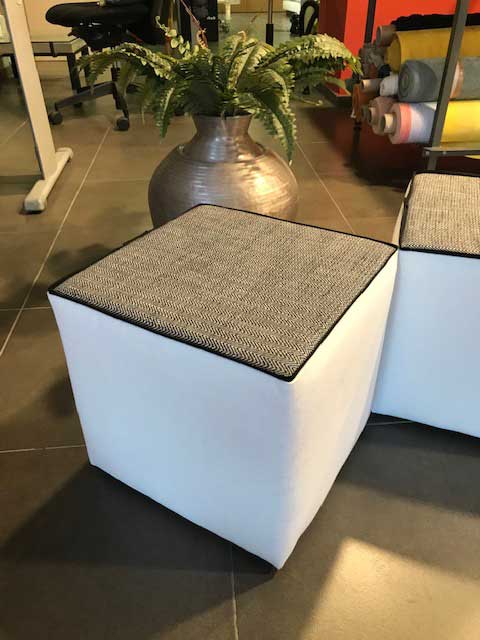 Poufs blanc et gris avec liseré plat noir et motifs à chevron. 